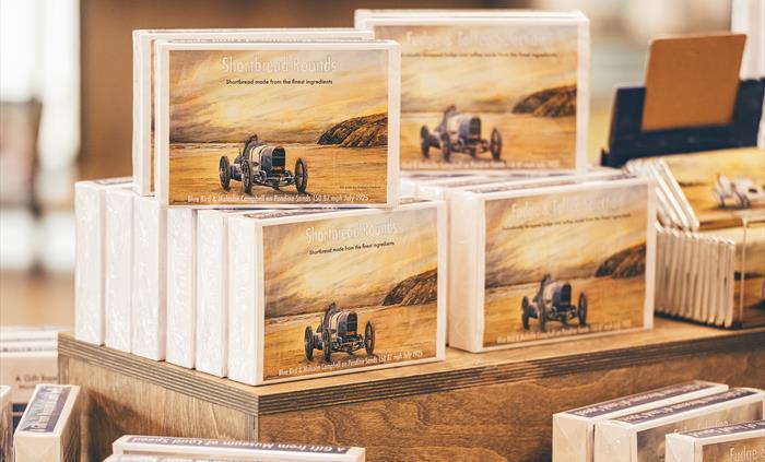 Boxes of fudge. A painting of the Bluebird car on Pendine Sands is on the cover of the boxes.